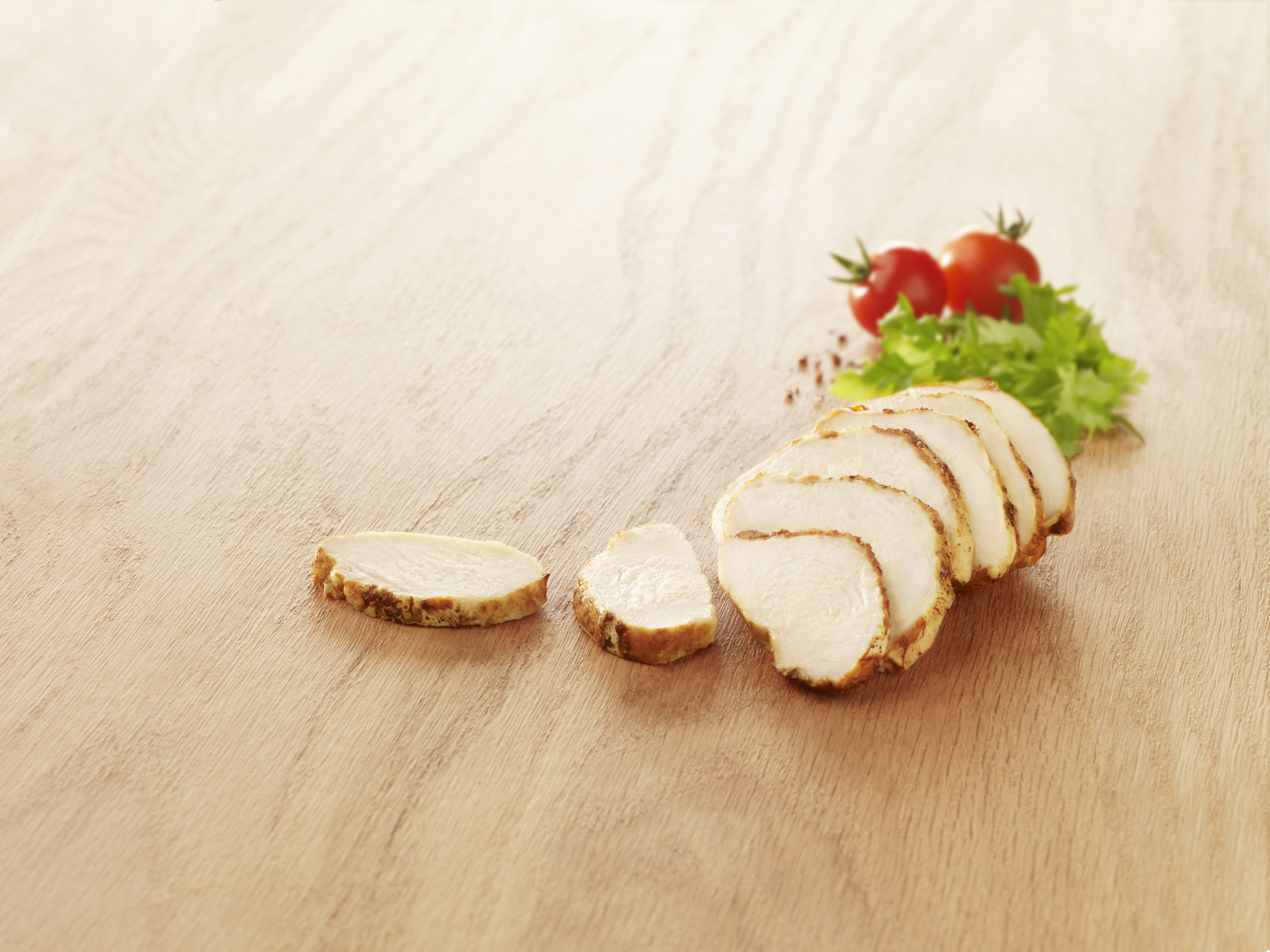 Visuel Emincé de poulet rôti sur planche en bois avec salade et tomate cerise