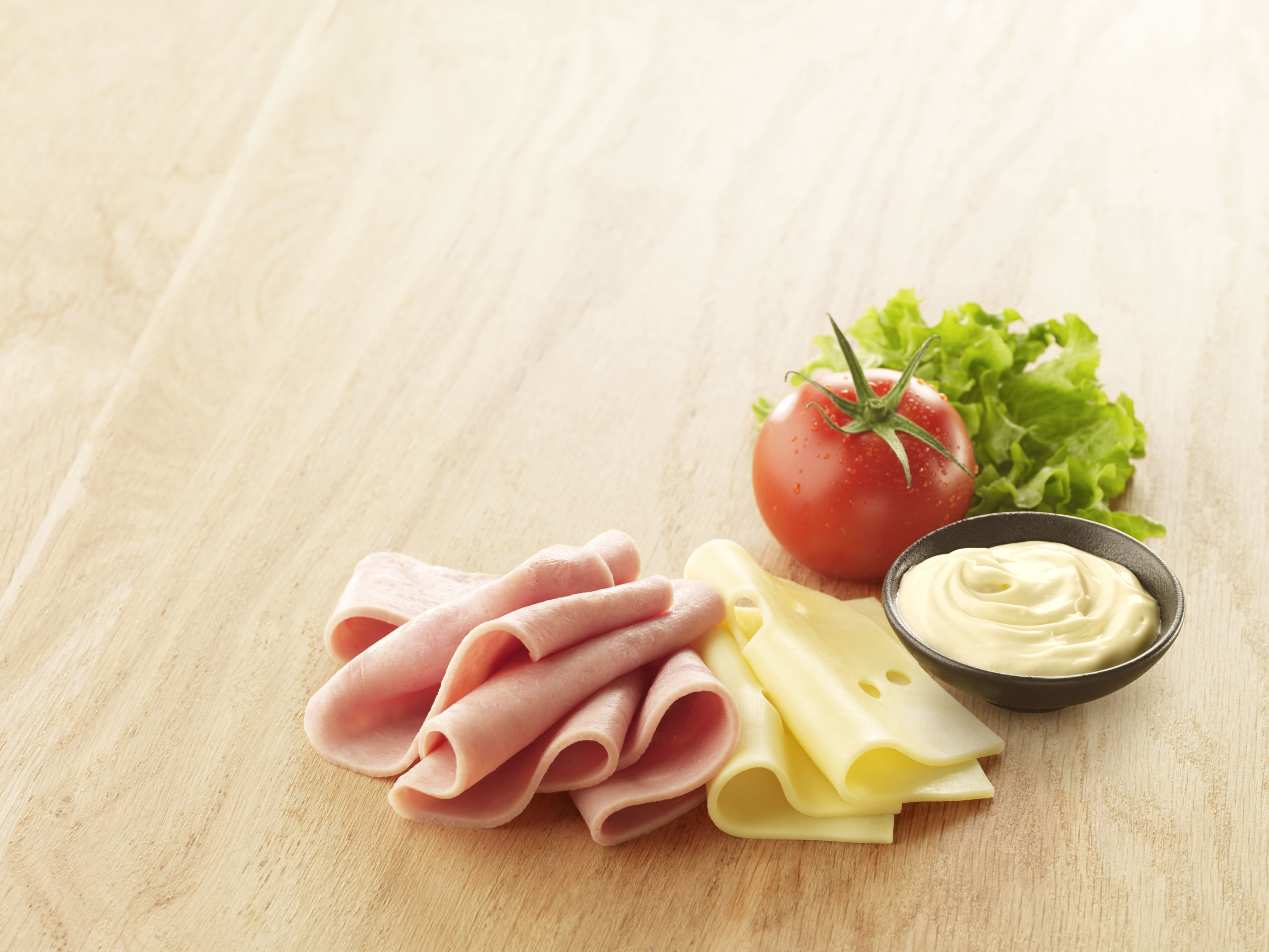 Visuel tranche maxi club avec jambon emmental tomate mayo et salade sur planche en bois