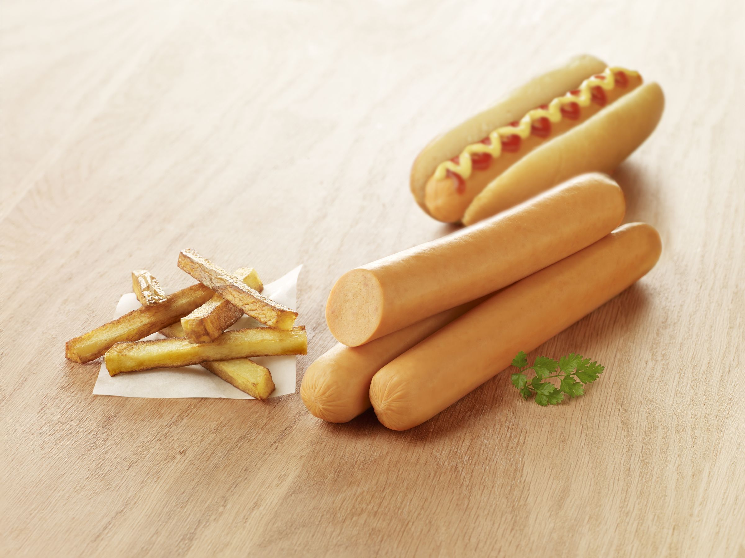 Visuel maxi knacks de volaille fumées halal avec pain hot dog et frites sur planche en bois