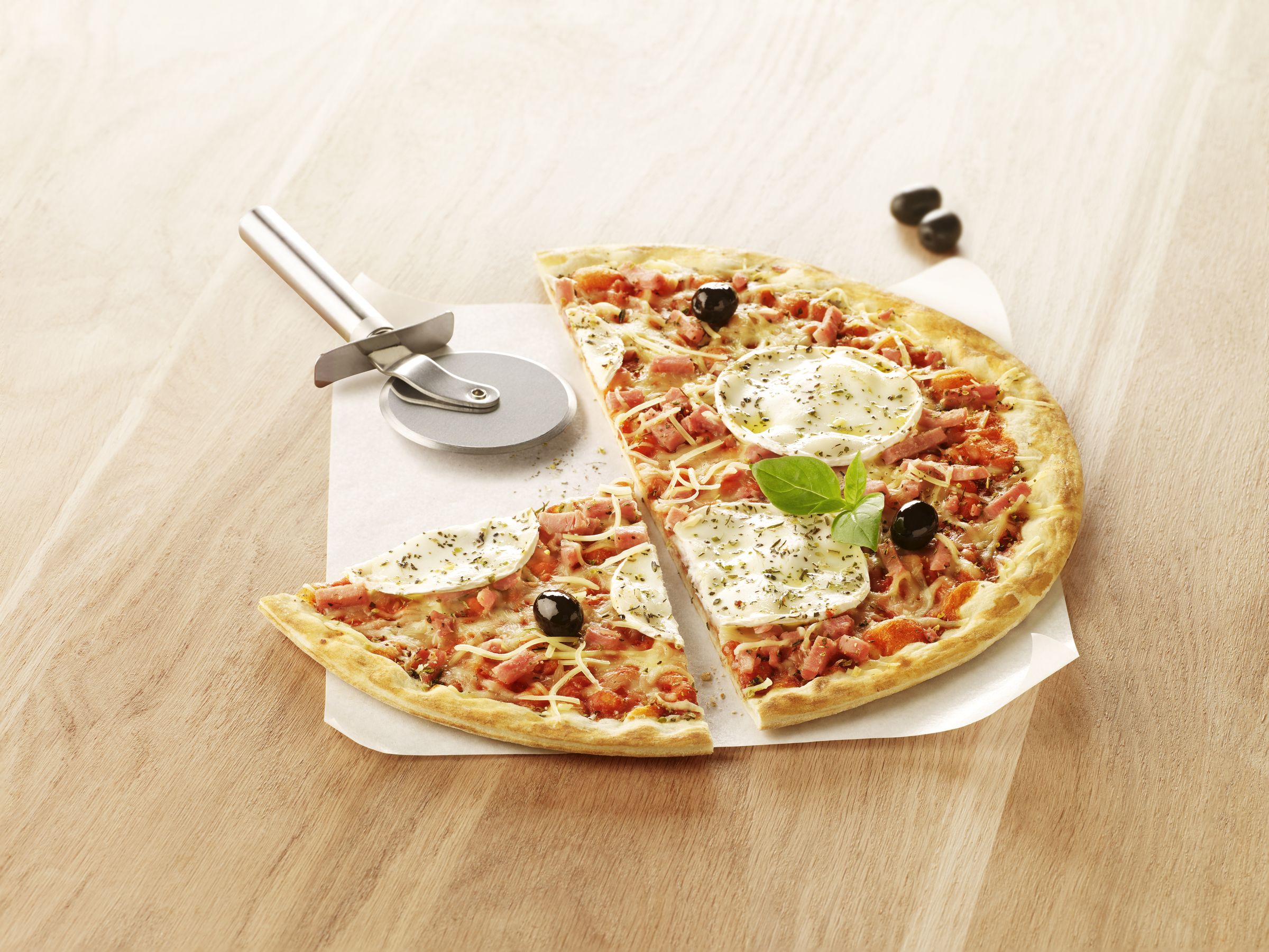 Visuel pizza halal au jambon de dinde avec chèvre sur planche en bois