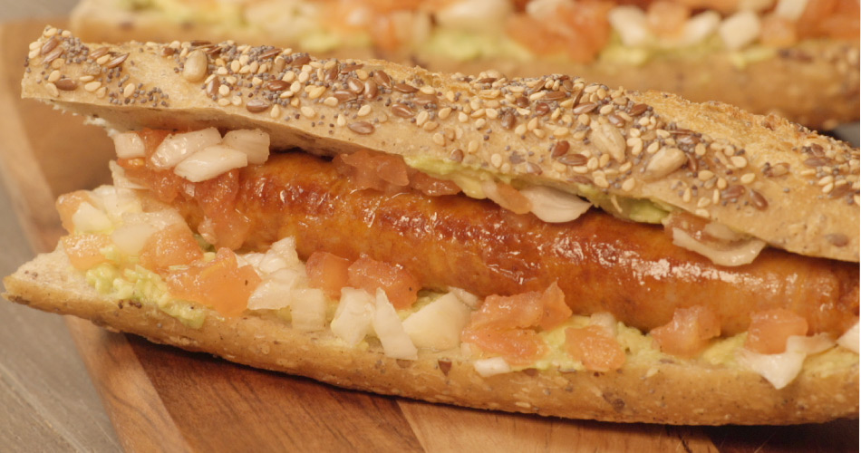 Recette hot dog avec merguez halal et origine France et oignons et avocat sur planche en bois - Réghalal