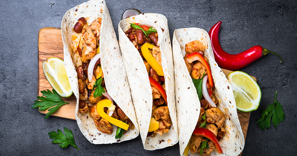 Recette tacos aiguillette de poulet halal et origine France avec poivrons sur planche en bois et fond ardoise - Réghalal